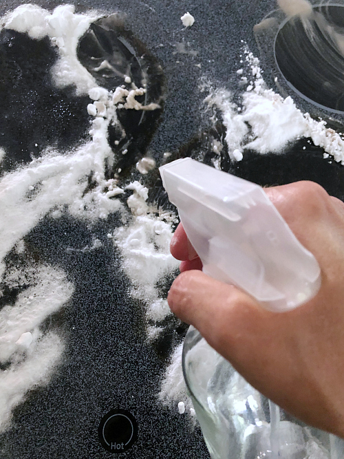 Applying water to baking soda to clean glass stove top