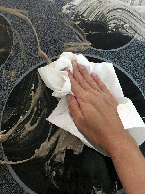 Cleaning A Glass Stove Top using paper towels to wipe clean