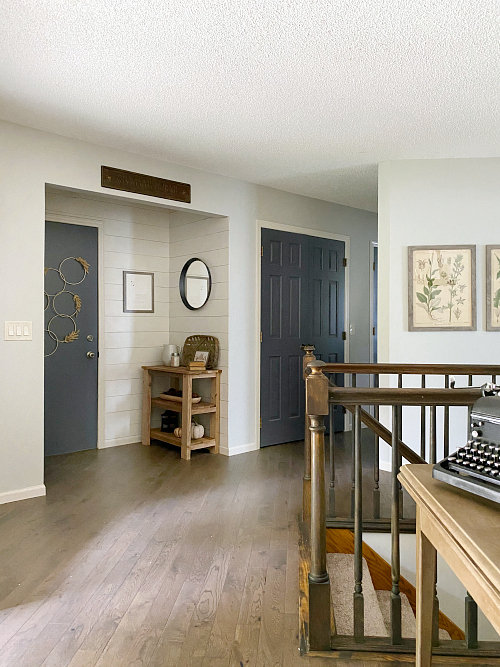 Farmhouse Entryway after $100 makeover. Features DIY shiplap on the walls, a DIY wood table as well as door on the plain door