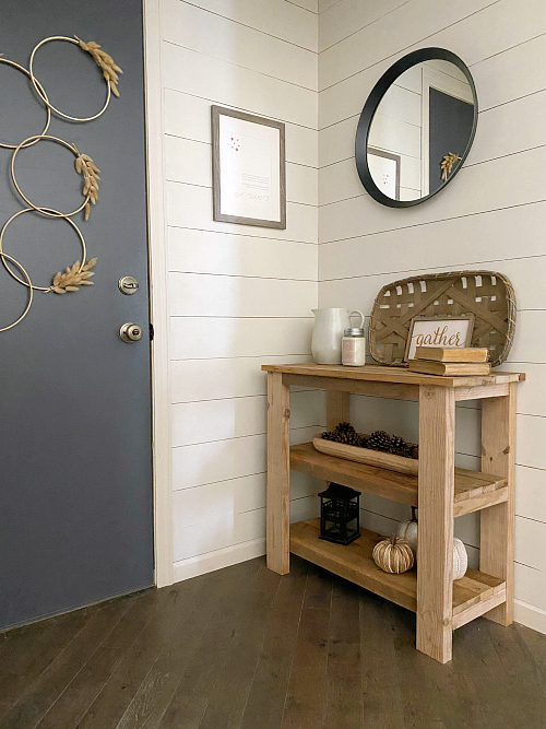 DIY wood console table in farmhouse entryway decorated with various fall decor items