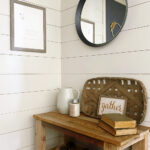 Wall decor for a farmhouse entry makeover including a round mirror and DIY print