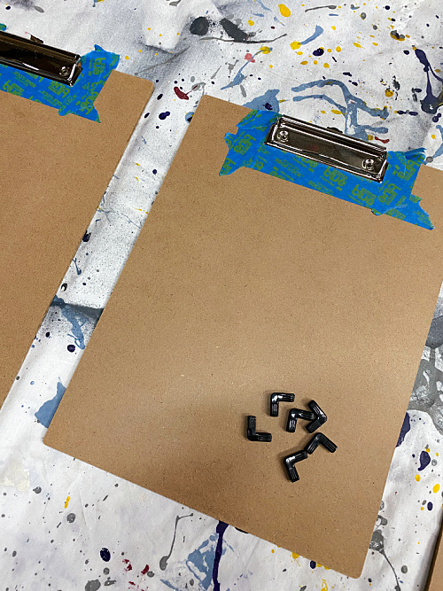 Applying painter's tape around clip of clipboard before applying a rusting solution.