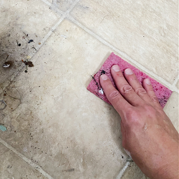 Scrubbing floor with sponge, using DIY floor cleaner recipe