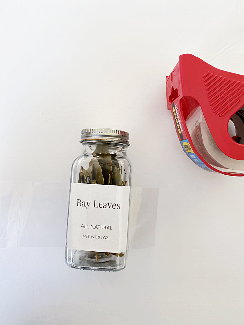 Securing spice jar labels with packing tape to create water and oil resistance