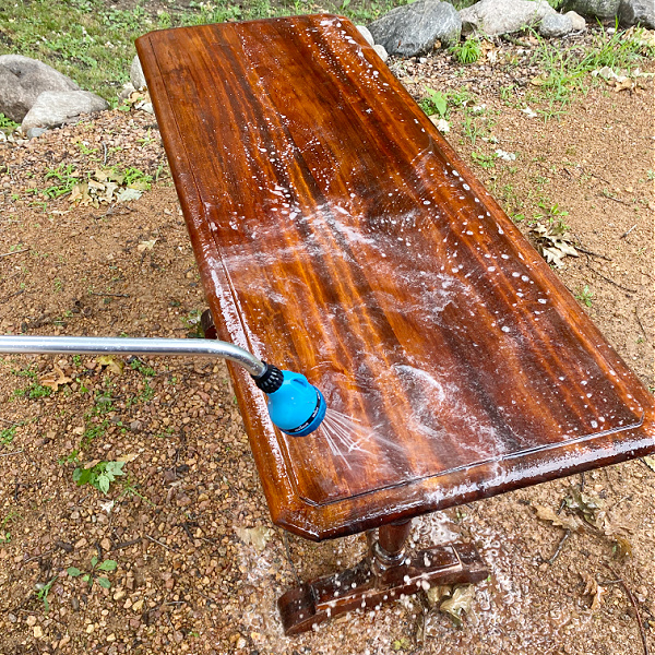 Rinsing table with hose to remove dish soap and oven cleaner