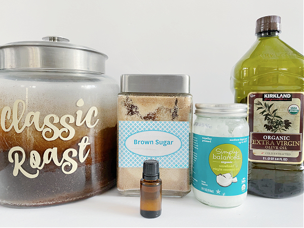 Ingredients needed to make a natural homemade sugar scrub recipe: coconut oil, olive oil, brown sugar, coffee grounds, and peppermint essential oil.