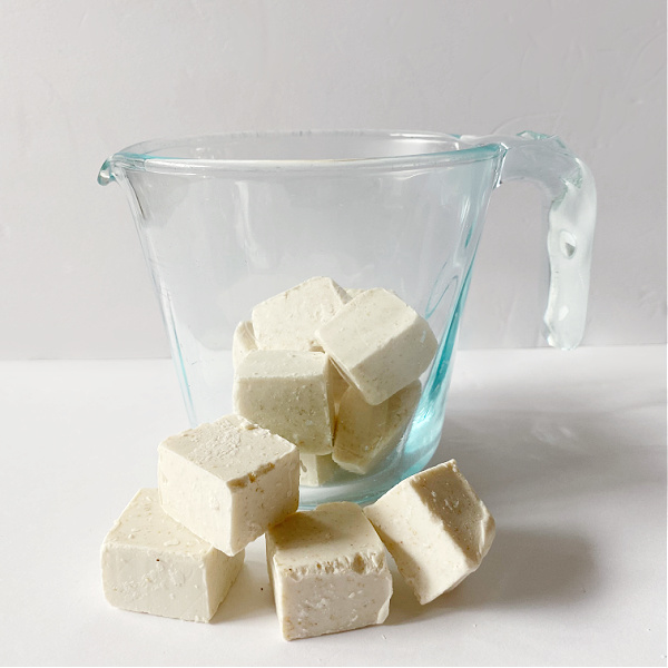 Cubed Oatmeal Soap Base in a glass measuring cup