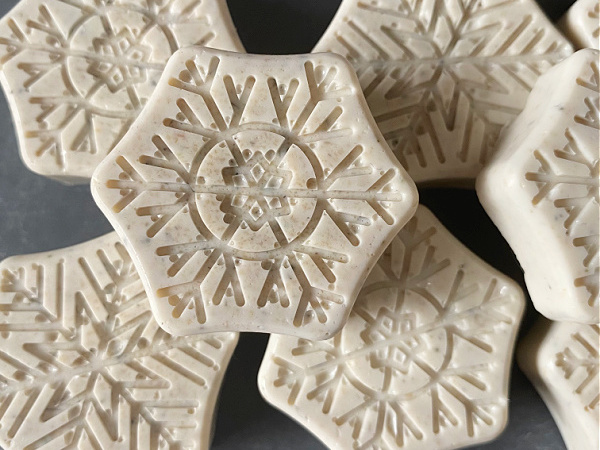 Homemade bar soap made with lavender essential oil in the shape of a snowflake.