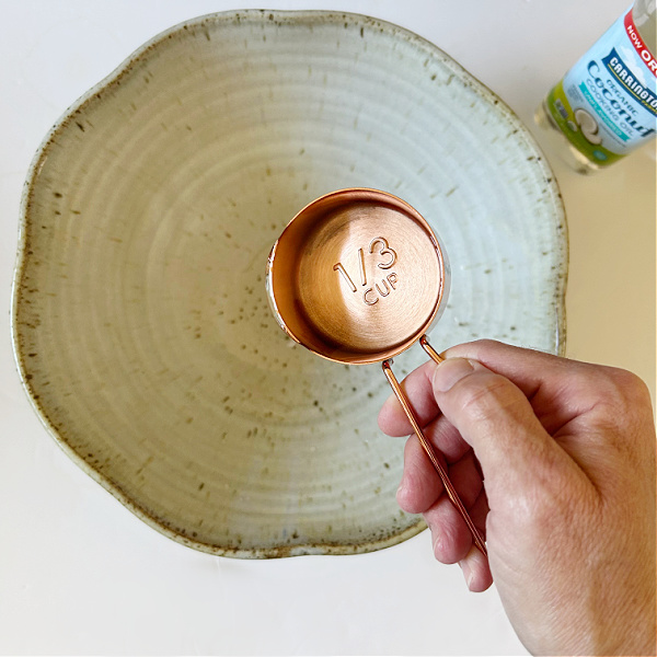 Adding fractionated coconut oil to mixing bowl