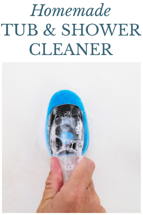 Scrubbing shower with a dish wand filled with DIY Shower Cleaner
