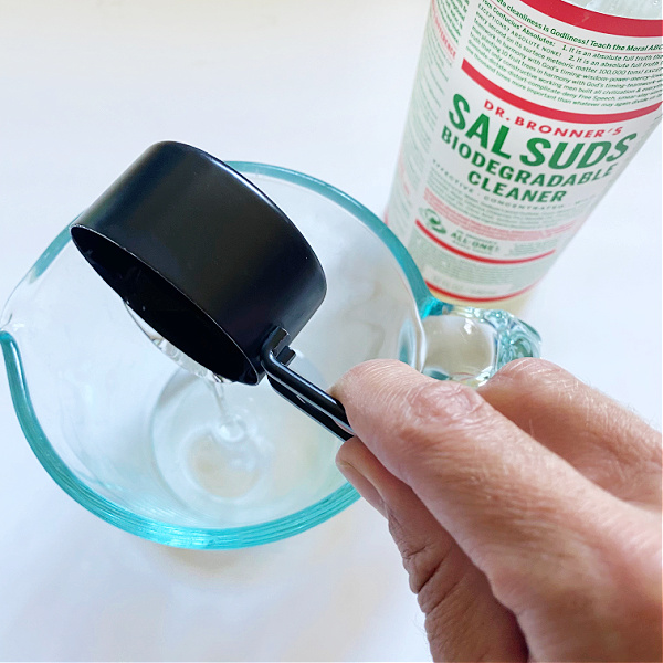 Adding Dr. Bonner's Sal Suds to homemade shower cleaner recipe.