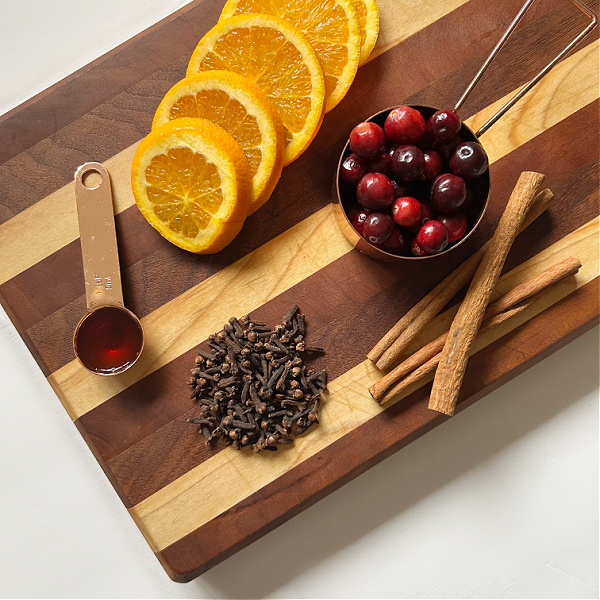 Fall simmer pot ingredients: orange slices, cranberries, cinnamon sticks, cloves, and vanilla