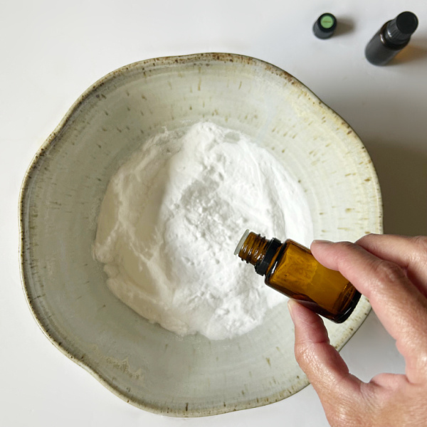 Adding essential oil to baking soda to make shower melts