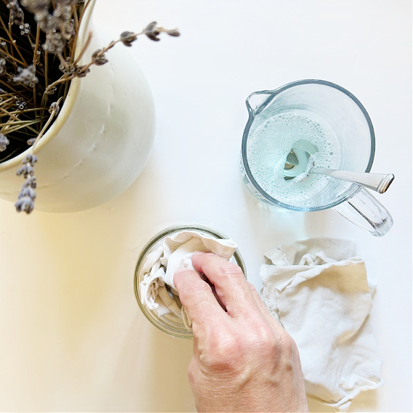 Adding cloth pieces to a mason jar to make DIY wipes