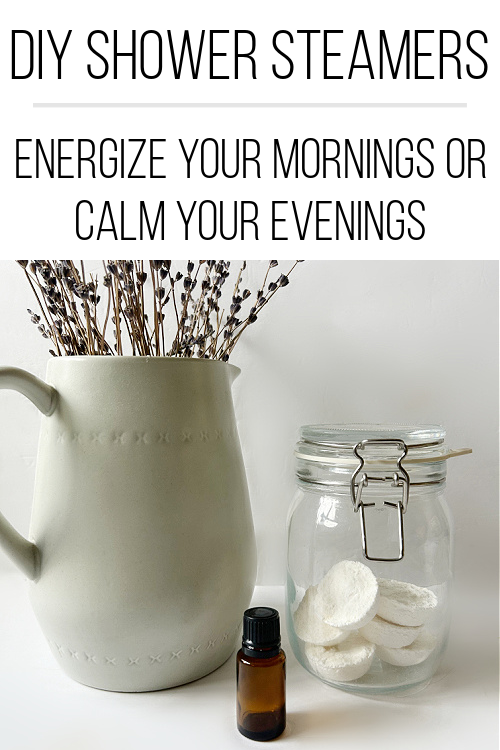 Jar full of DIY Shower Steamers next to a bottle of essential oil and a vase of dried lavender