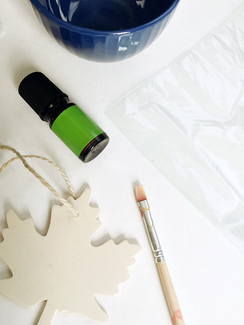 Items needed to make a homemade car freshener: Wood ornament, paintbrush, essential oil