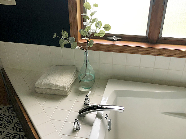 Bathtub with folded towel and eucalyptus