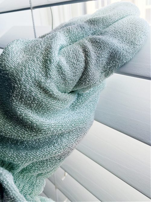 Dusting Wood Blinds with a dusting glove