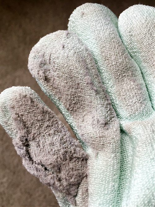 Dust on dusting glove used to clean wood blinds