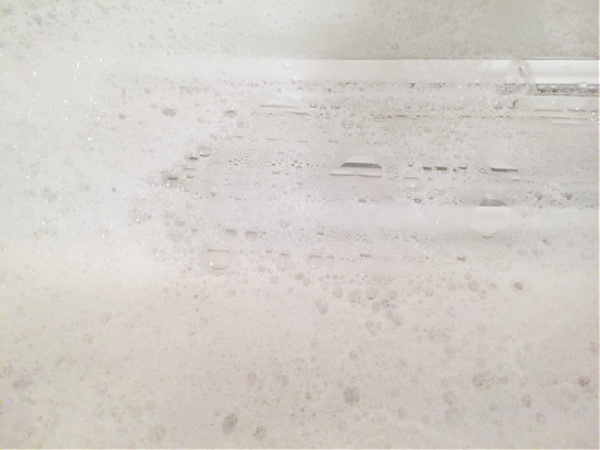 Mini blinds soaking in bathtub with warm soapy water