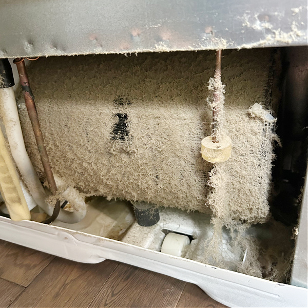 Dusty refrigerator coil before cleaning