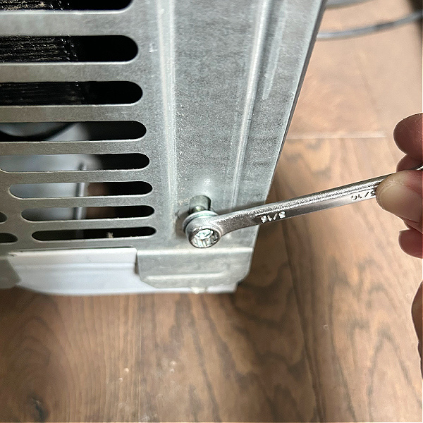 Removing back panel on refrigerator to clean refrigerator coils