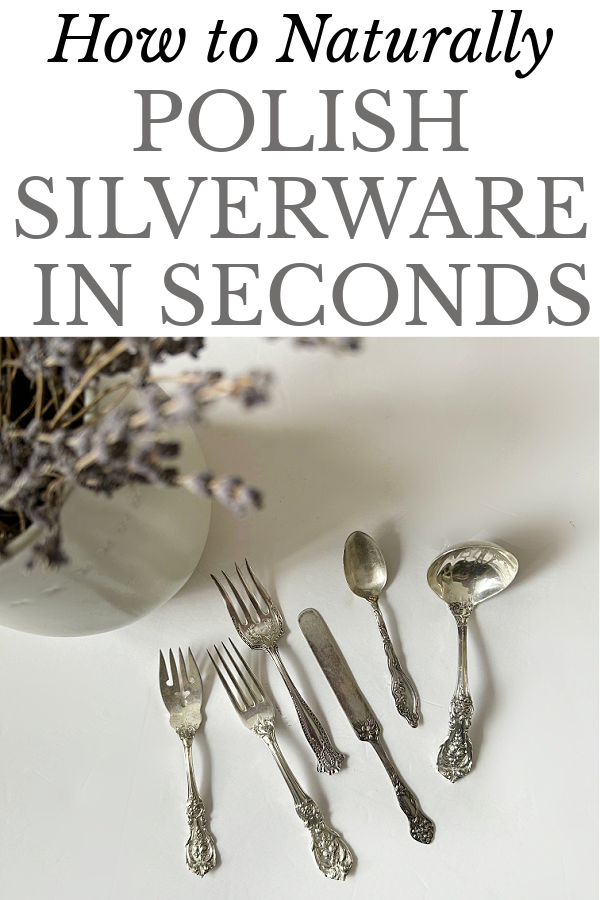 Silverware laying on counter next to vase of dried lavender