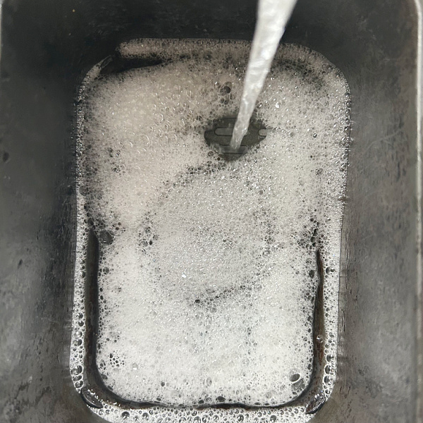 Adding dish soap and water to air fryer basket