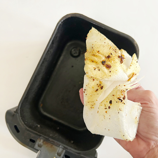 Removing grease and food from air fryer prior to cleaning