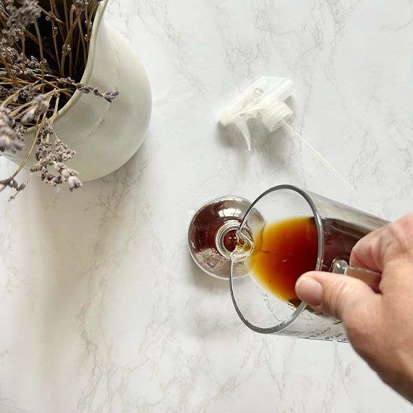 Pouring black tea into a spray bottle
