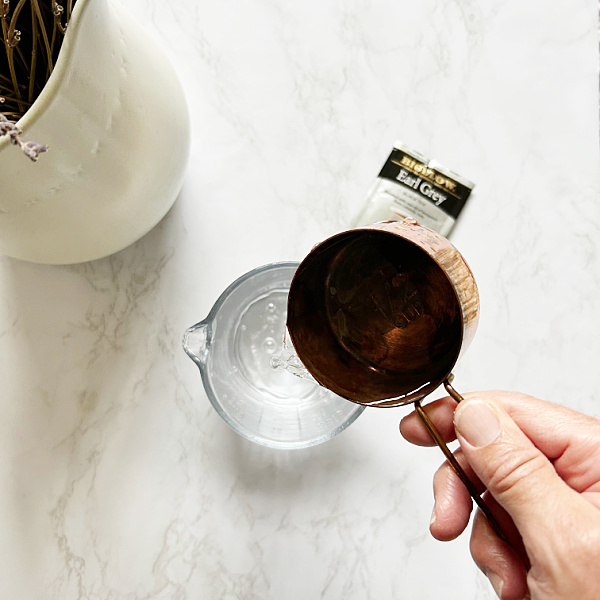 Adding water to glass liquid measuring cup